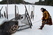 Vassilly Pyak, a Forest Nenets reindeer herder, checking his fish trap set under the ice on the Kazym River near his homestead. Numto, Khanty Mansiysk, Northwest Siberia, Russia