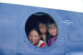 Nenets children look out of the window of a helicopter that will take them back to boarding school after the summer holiday. Yamal Peninsula, Western Siberia, Russia