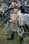 Alexey Serotetto, a Nenets boy coils his lasso as he stands by a reindeer corral. Yamal. Siberia, Russia.