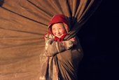 Neseynya Serotetto, a Nenets girl, plays at the entrance to her family's tent. Yamal, Siberia, Russia