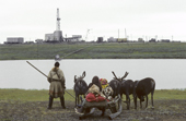 Nenets herder & his children in front of a gas rig on the tundra near Bovanenkovo. Yamal.Siberia.Russia