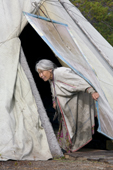 Kaduni, a Forest Nenets grandmother, at the entrance to her summer tent. Purovsky Region, Yamal, Western Siberia, Russia