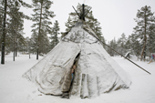 Two Forest Nenets girls peer out of her family's tent at a winter camp in the Purovsky region of the Yamal. Western Siberia, Russia.