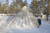 Kaduney, a Forest Nenets woman beats snow of her tent at a winter reindeer herders' camp in the Purovsky region of the Yamal. Western Siberia, Russia