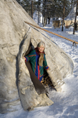 Kaduney Piak, an elderly Forest Nenets woman, in the entrance of her family's reindeer skin tent at their winter camp. Purovsky region, Yamal, Western Siberia, Russia