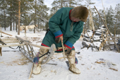 Langu Piak, a Forest Nenets herder, uses a bow drill to repair one of his sleds at his winter camp. Purovsky region, Yamal, Western Siberia, Russia.
