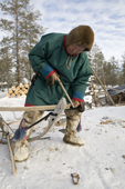 Langu Piak, a Forest Nenets herder, uses a bow drill to repair one of his sleds at his winter camp. Purovsky region, Yamal, Western Siberia, Russia.