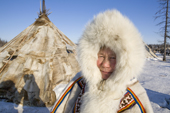 Tanya Seratetto, in traditional Nenets winter dress, outside a reindeer skin tent. Yamal, western Siberia, Russia