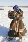 A Nenets woman uses her mobile phone to photograph at a reindeer herders festival in the Yamal. Western Siberia, Russia