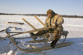 Piotr Laptander, a Nenets reindeer herder, repairing a sled before the Spring migration. Yamal, Western Siberia, Russia