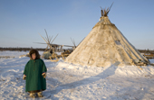 Paedavyaku, a Nenets boy, outside his family's reindeer skin tent at their winter camp in the Yamal. Western Siberia, Russia
