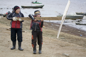 Khanty boys holding a propeller made from drift wood in a strong wind by the River Ob. Yamal, Western Siberia, Russia