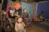In a hut at a fishing camp on the River Ob, Yelena, a Khanty woman, plaits her daughter's hair. Yamal, Western Siberia, Russia