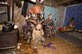 In a hut at a fishing camp on the River Ob, Yelena, a Khanty woman, plaits her daughter's hair. Yamal, Western Siberia, Russia