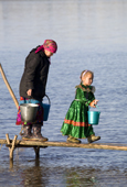 Lidiya Tokhma, a Khanty woman, collecting water with her grandaughter, Alona, at a fishing camp on the river Ob near Aksarka. Yamal, Western Siberia, Russia