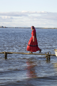 Oksana Tokhma, a young Khanty woman, walks along a wooden jetty at a fishing camp near Aksarka on the River Ob. Yamal, Western Siberia, Russia