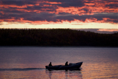 Khanty fishermen out fishing in their Budarka (boat) at sunset on the River Ob near Aksarka. Yamal, Western Siberia, Russia