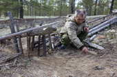 Gennadiy Kubolev, a Selkup hunter, setting a traditional 'chang' (deadfall trap) to catch capercaille in a forest clearing. Krasnoselkup, Yamal, Western Siberia, Russia