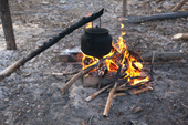 A kettle hangs over an open fire to boil at a Selkup camp in the forest. Krasnoselkup, Yamal, Western Siberia, Russia