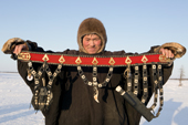 Nikolai Taibery, a Nenets reindeer herder, holds his traditional belt with a knife, tools and a bear tooth amulet hanging from it. Yamal, Western Siberia, Russia