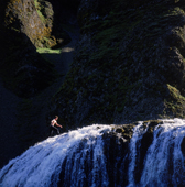 Male climbing Stjornarfoss Waterfall, Iceland