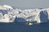 A fishing boat heads into the Ilulissat ice Fiord. West Greenland. A UNESCO world Heritage site.