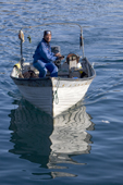 Inuit fisherman in his boat in the harbour at Ilulissat. West Greenland