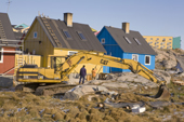 A digger infront of brightly coloured modern houses in Ilulissat. West Greenland