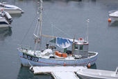 A wooden fishing boat covered in snow in Ilulissat harbour. West Greenland.