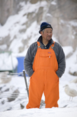 An Inuit fisherman standing in the harbour at Ilulissat. West Greenland