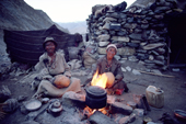 Yak herders sit by the fire and make butter in goats skins. Ladakh, India
